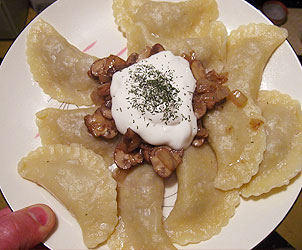 Pierogi with mushroom and sauerkraut filling, covered with cream