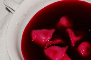 Polish traditional uszka dumplings in red borscht