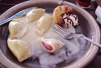 Pierogi with strawberries covered with cream